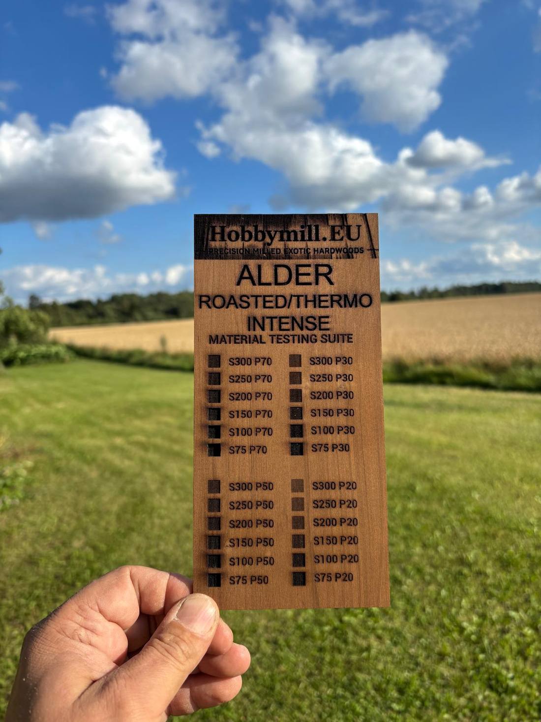 Roasted thermo alder intense 3 mm laser test card — dark chocolate brown surface with black engraving