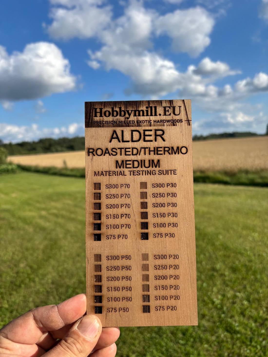 Roasted thermo alder medium 3 mm laser test card — warm caramel brown surface with near-black engraving